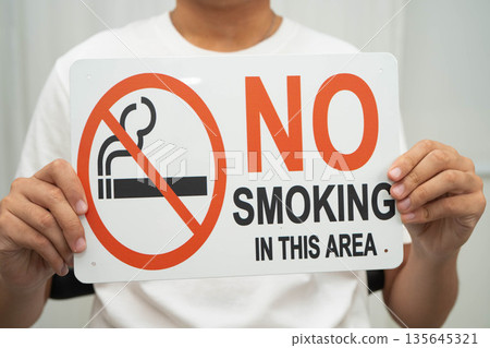 Male holding a no smoking sign. Male holding a no smoking sign. 135645321