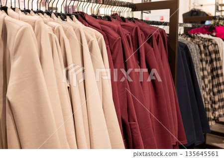 Neatly arranged assorted colored jackets on store rack Neatly arranged assorted colored jackets on store rack 135645561