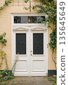 Elegant white wooden door with decorative glass in yellow brick wall 135645649