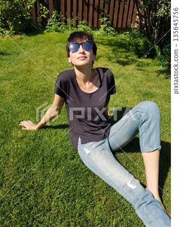 Happy Woman Holding Corgi Puppy in Sunny Garden Happy Woman Holding Corgi Puppy in Sunny Garden 135645756