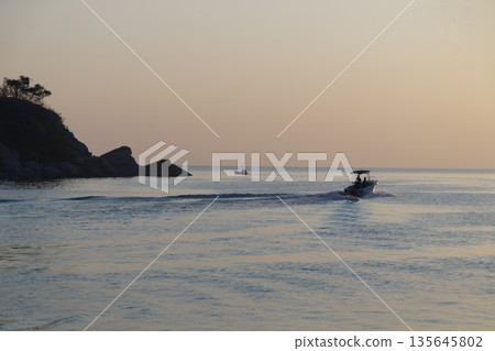 Fishing boat and dawn.Fishing boat with fishermen at dawn. 135645802