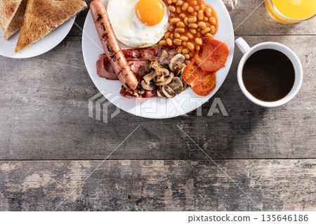 Full English breakfast with fried egg, bacon, sausages and beans Full English breakfast with fried egg, bacon, sausages and beans 135646186