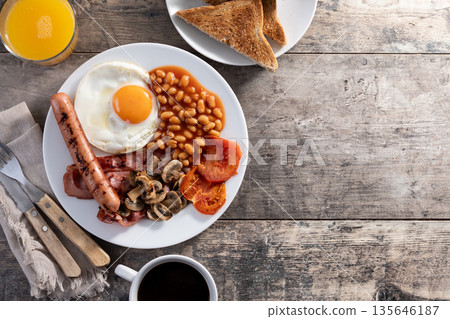 Full English breakfast with fried egg, bacon, sausages and beans Full English breakfast with fried egg, bacon, sausages and beans 135646187