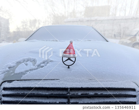 Decorating the car for the new year and Christmas. Santa's red cap. Close up photo Decorating the car for the new year and Christmas. Santa's red cap. Close up photo 135646911