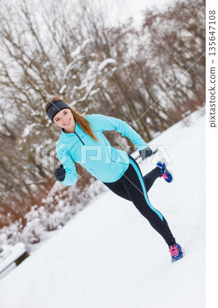 Winter sport, girl exercising in park 135647108