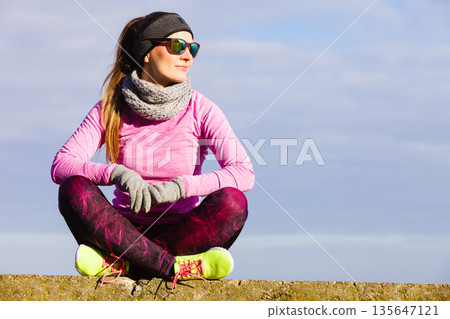 Woman resting after doing sports outdoors on cold day Woman resting after doing sports outdoors on cold day 135647121