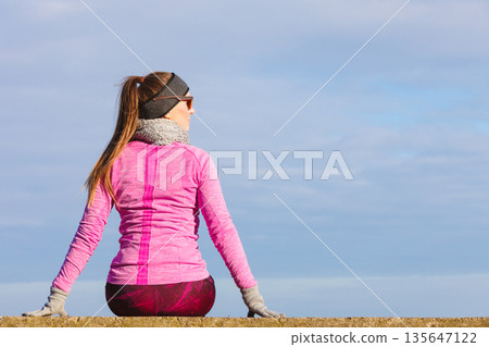 Woman resting after doing sports outdoors on cold day 135647122