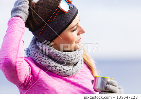 Fit woman in cold day warming up drink tea 135647128
