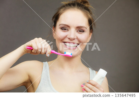 Woman brushing cleaning teeth 135647495