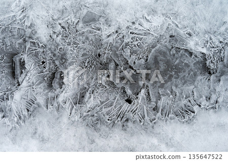 Macro shot of ice on a creek. Natural winter background.Macro shot of ice on a creek. Natural winter background. Macro shot of ice on a creek. Natural winter background.Macro shot of ice on a creek. Natural winter background. 135647522