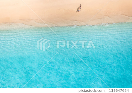 Summer aerial beach top view couple walking sandy shore calm waves landscape Summer aerial beach top view couple walking sandy shore calm waves landscape 135647634