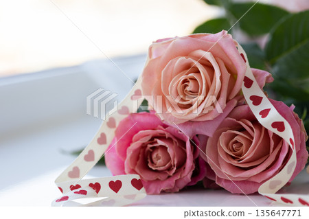 Bouquet of roses with gift ribbon. Closeup. Floral gift. 135647771