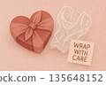 Heart shaped gift box with fabric wrap and care tag promoting sustainable eco friendly packaging on pastel pink background for Valentine celebration and conscious gifting 135648152