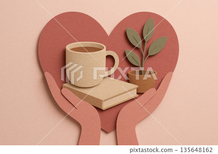 Papercut hands holding heart with coffee cup book and plant representing self care slow living mindfulness valentine concept in pink terracotta earth tone palette 135648162