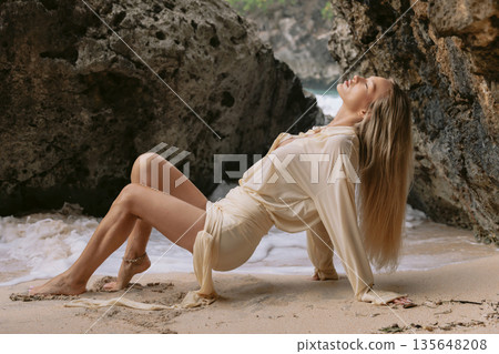 Woman posing on sandy beach between rocks with sea foam and natural light Woman posing on sandy beach between rocks with sea foam and natural light 135648208