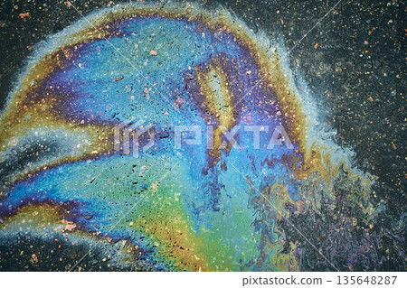 Colorful Oil Slick Seen on a Wet Pavement After Rain Near a City Street During the Daytime 135648287