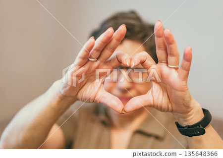 senior woman making a heart shape 135648366