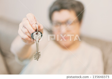 Woman holding a couple of keys 135648373
