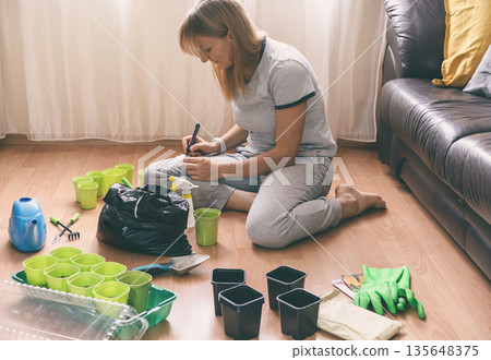 woman plant seedlings at home woman plant seedlings at home 135648375
