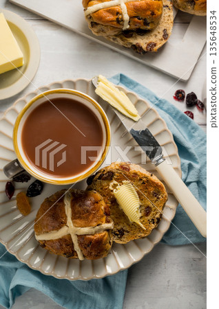 Cross Buns with butter in a plate. Breakfast concept. Top view. Easter treat buns Cross Buns with butter in a plate. Breakfast concept. Top view. Easter treat buns 135648534