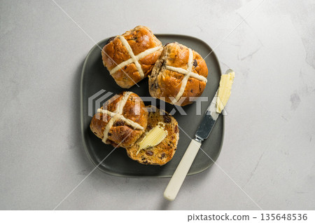 Cross Buns with butter in a plate. Breakfast concept. Top view. Easter treat buns Cross Buns with butter in a plate. Breakfast concept. Top view. Easter treat buns 135648536
