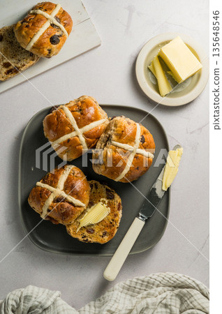 Cross Buns with butter in a plate. Breakfast concept. Top view. Easter treat buns Cross Buns with butter in a plate. Breakfast concept. Top view. Easter treat buns 135648546