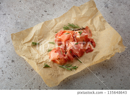 Prosciutto with rosemary wrapped in paper. Prosciutto with rosemary wrapped in paper. 135648643