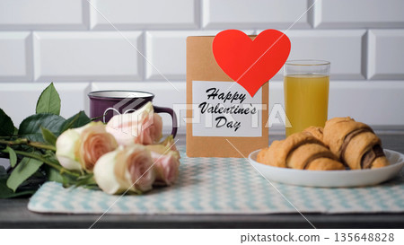 Happy Valentines Day postcard beside croissants, orange juice, hot tea and roses Happy Valentines Day postcard beside croissants, orange juice, hot tea and roses 135648828