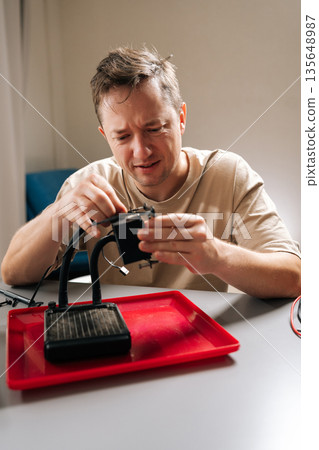 Vertical portrait of repairman frustrated by complex computer cooling system repair project, needing technical support, facing diy challenges, and trying to solve hardware maintenance issue. 135648987