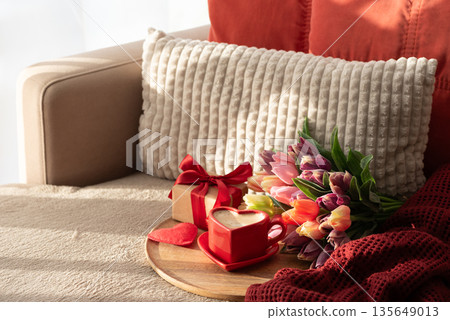 Heart Shaped Coffee Cup with Colorful Tulips and Candies. Cozy Romantic Flatlay on Sofa for Valentines Day Celebration Heart Shaped Coffee Cup with Colorful Tulips and Candies. Cozy Romantic Flatlay on Sofa for Valentines Day Celebration 135649013