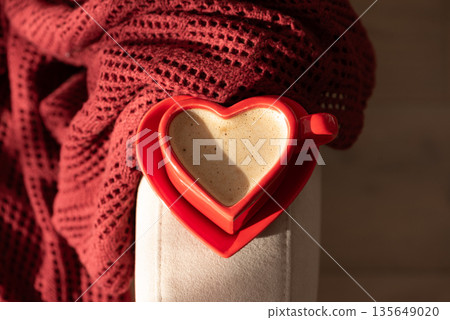 Top View Heart Shaped Coffee Cup on Armchair with Red Blanket. Cozy Valentines Day Still Life 135649020