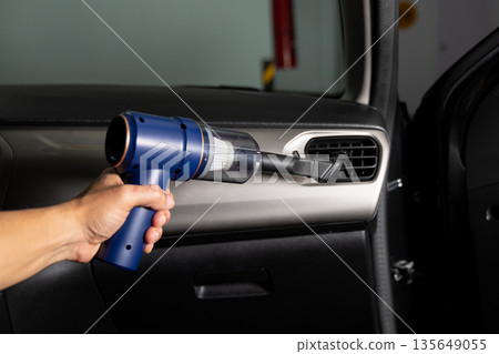 A person is cleaning the inside of a car with a vacuum A person is cleaning the inside of a car with a vacuum 135649055
