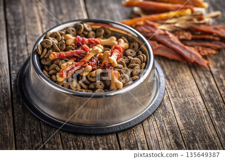 Dog food. Snack sticks for dogs and dry kibble food on wooden table. 135649387