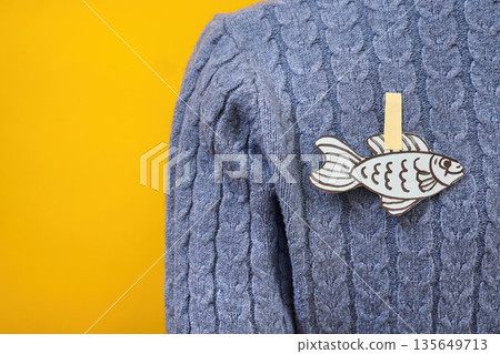 Paper fish prank attached to blue sweater for april fools' day 135649713