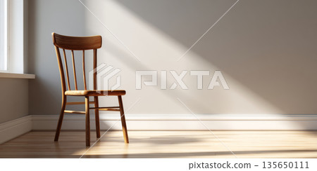 Minimalist wooden chair placed in a sunlit empty room with light hardwood flooring and soft shadows on a plain beige wall 135650111