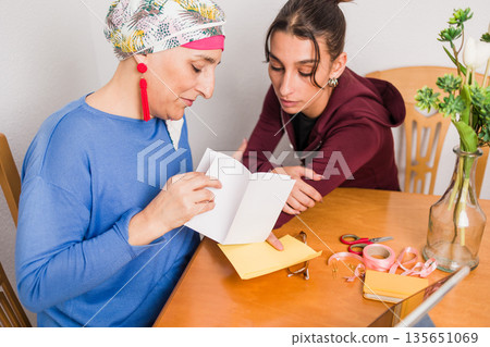 Women supporting breast cancer awareness and volunteering at home 135651069