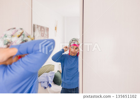 Woman with cancer embracing beauty in front of mirror Woman with cancer embracing beauty in front of mirror 135651102