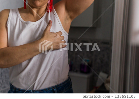 Woman hand performing breast cancer self examination 135651103