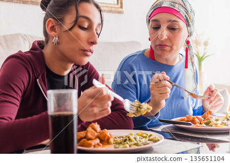 Mother and daughter sharing meal during chemotherapy recovery 135651104