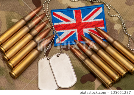 Ammunition and military identification tags placed near United Kingdom flag. 135651287