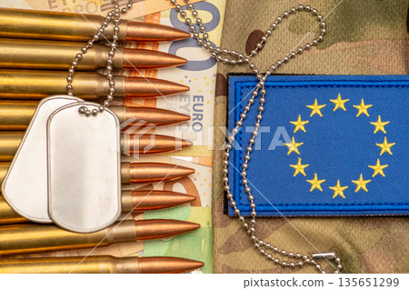 Army identification tags and ammunition on euro banknotes with European Union patch. 135651299