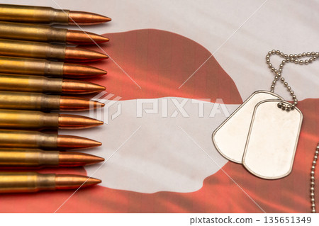 Ammunition and soldier identification tags on Greenland flag symbolizing armed forces. 135651349