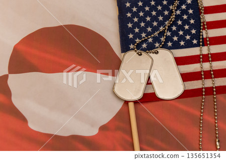 Soldier dog tags placed on United States and Greenland flags. Soldier dog tags placed on United States and Greenland flags. 135651354