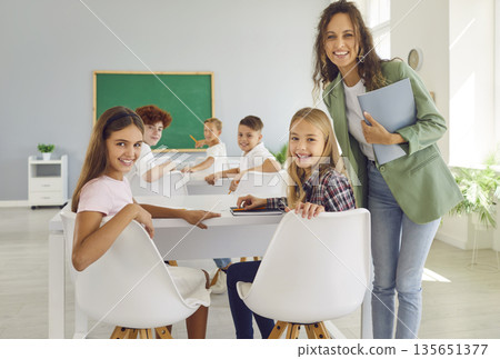 School teacher and pupils portrait, group of smiling schoolchildren in class, happy friendly mates 135651377