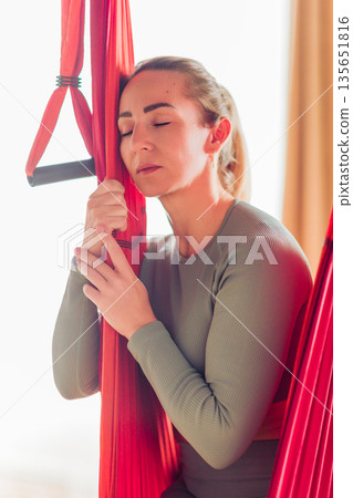 Woman practicing aerial yoga, finding balance and relaxation 135651816