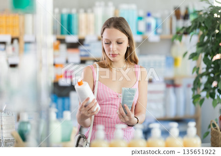 Woman in dress choosing cream in pharmacy Woman in dress choosing cream in pharmacy 135651922