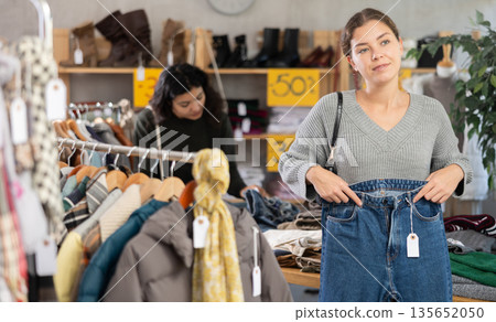 American woman chooses jeans in a discount store American woman chooses jeans in a discount store 135652050