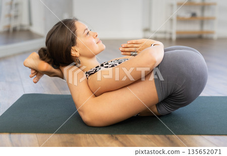 Young sporty attractive woman wearing sportswear practicing yoga, doing Halasana exercise and variety of Plough pose, difficult yoga pose in modern yoga studio Young sporty attractive woman wearing sportswear practicing yoga, doing Halasana exercise and variety of Plough pose, difficult yoga pose in modern yoga studio 135652071
