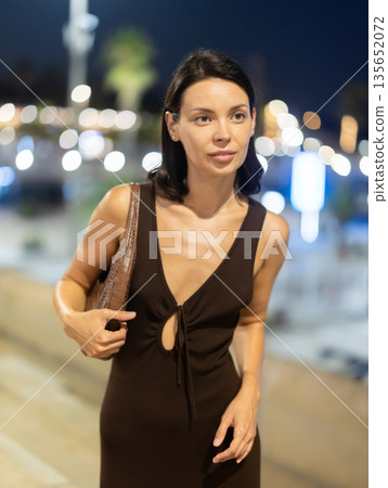 At night, girl walks around old city district Barceloneta, in vicinity of sea pier. At night, girl walks around old city district Barceloneta, in vicinity of sea pier. 135652072