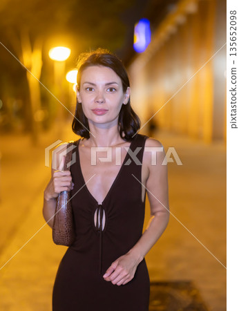 At night, smiling girl walks around old city district Barceloneta, in vicinage of Citadel Park 135652098